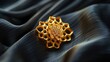 Close-up of a gold hexagonal jewelry piece on a black satin surface, highlighting intricate craftsmanship and luxury