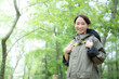 Woman enjoying mountain climbing and other activities in the fresh greenery of spring and summer, looking at the camera Image of fun outdoor activities