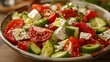 A high-angle view of a simple Greek salad with tomatoes, cucumbers, and feta cheese.