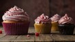 Delicious pink cupcakes arranged on a wooden table