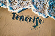 Tenerife, Spain written in the sand on a beach. Spanish tourism and vacation background