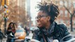 © Suleyman - Two happy Black women chat while one bikes through the city.