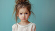 A little girl with her hair in pigtails is looking down and frowning. She is wearing a white shirt and she is upset. Portrait of cute little upset girl, naughty kids idea