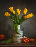 Fototapeta Natura - Still life with a bouquet of yellow tulips and red oranges.