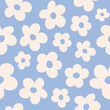 Seamless pattern with white groovy daisy flowers on a blue background. Vector illustration