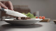 Closeup man slicing steak on white plate on kitchen countertop