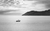 Fototapeta  - Solitary Fishing Boat at Dusk Near Coastal Mountain, Catalonia