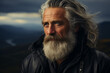 Portrait d'un vieil homme aux cheveux gris et à la barbe dans les montagnes, regardant quelque chose au loin, ciel bleu foncé avec des nuages, la lumière du soleil tombant sur son visage, portant une 
