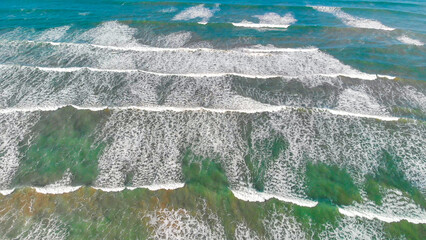 Wall Mural - Overhead aerial view of gentle waves along the beautiful shoreline