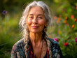 Portrait of modern senior woman with her eyes half-closed. Elderly gray-haired lady meditates in summer garden. Relaxation as method of restoring woman's body. Blurred background. Peaceful environment