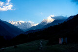 Fototapeta  - Darkened fields and mountain peaks still shining with sunlight