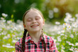 a happy young girl with special needs, smiling and looking at the camera in a garden