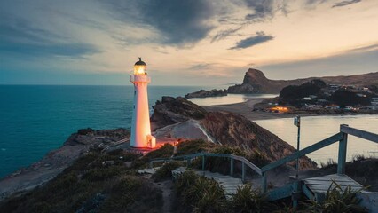 Wall Mural - Castlepoint lighthouse glowing on Wairarapa coastline in the sunset at New Zealand