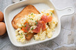 Beige serving tray with scrambled eggs and smoked salmon on toast, horizontal shot, elevated view, middle close-up