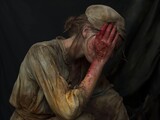 A woman is sitting on the ground with her hands on her head. She has a bloody hand on her face and a bloody hand on her arm. The woman is wearing a dirty shirt and a hat. The scene is dark and eerie