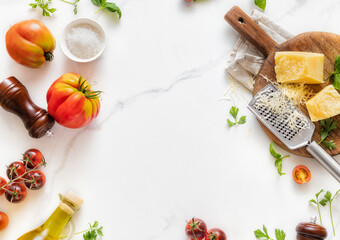 Canvas Print - Frame of Italian food cooking ingredients background with fresh vegetables, herbs, spices olive oil and cheese on white stone table top view. Healthy eating