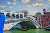 Fototapeta  - View of the Rialto Bridge and gondolas of the Grand Canal on a sunny day in Venice, Italy