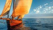 Close-up shot of a large orange sailboat. Floating in the middle of the blue sea The backlight has beautiful lobes on the sail.