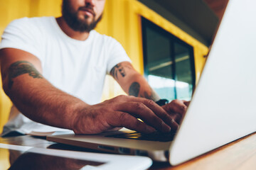 Fototapete - Cropped image of skilled male programmer concentrated on coding typing on laptop computer,selective focus on male hands keyboarding publication on netbook, blurred guy working on freelance online