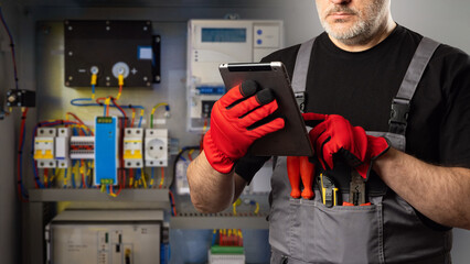 Poster - man is electrician. electrical equipment installer. electrician with tablet computer in his hands. c