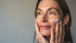 © Cosmeticthingz - Middle-aged woman applying cosmetics to her face, close-up. Cosmetics advertisement photo. Cosmetics photo, beauty industry advertising photo. Mother's Day.