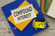 compound interest text on the page. yellow notepad on blue folder