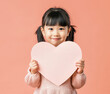 Small Asian girl holding empty paper heart in front of her. Generative AI