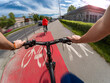 A couple riding bikes together in sunny weather in an urban area. First-person view - POV