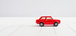 illustrazione con modello di automobile in scala su superficie in legno bianco
