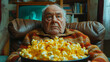 An old man sitting on the couch with a bowl of popcorn 