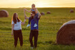A harmonious family in a summer meadow during an evening walk in the fresh air