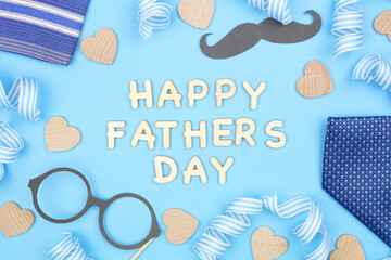 Wall Mural - Happy Fathers Day message with frame of gifts, decor, ties and ribbon on a blue background. Top view.