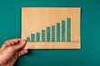Close-up of a Hand Holding a Rising Bar Chart - Growth, Success, Financial Analysis