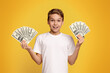 © Prostock-studio - Young Boy Holding Two Stacks of Money