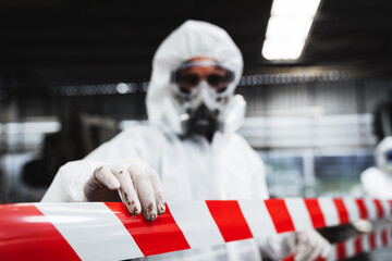 Workers in protective suits inspect chemicals in an old factory, safeguarding against hazards and contamination. This is part of an emergency response to a radioactive accident.