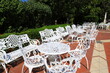 Summer garden furniture. Retro forged white tables and chairs in street cafe, terrace,