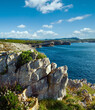 Spring evening Atlantic Ocean rocky coastline landscape with pink flowers in front (Cantabria, Spain). Two shots stitch image.