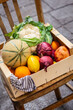 A box of vegetables and fruits outdoors near a street shop, real photo.