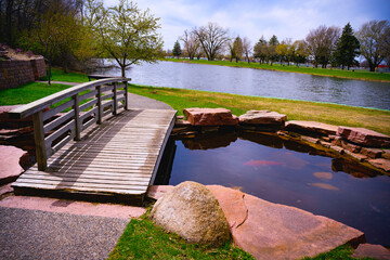 Wall Mural - Wooden Bridge over the little pond and stone footpath at Terrace Park Japanese Gardens in Sioux Falls, South Dakota, USA