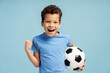 © Maria Vitkovska - Portrait of emotional child boy holding soccer ball in his hand, isolated on blue background