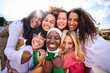 © CarlosBarquero - Portrait of group of beautiful young multiracial girl friends community hugging and looking at camera outdoor. Smiling only women together embraced affectionately. Female friendships and quality time