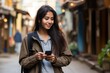 © Adobe Contributor - Young woman using her smartphone in the street