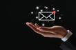 © New Africa - Incoming email. Man holding virtual envelope against black background, closeup