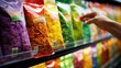© Adobe Contributor - A hand reaching for a bag of chips on a grocery store shelf