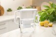 Water filter jug, glass and lemons on white marble table in kitchen