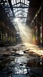 An abandoned factory building with broken windows and sunlight shining through the roof