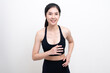 © PhugunStock - Attractive Asian woman in black workout clothes doing arm stretching on white background. Confident young female athlete body warm up before workout on isolated.
