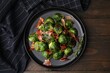 Delicious roasted Brussels sprouts and bacon on wooden table, top view