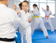 Boy student with male coach reproduce duel and train to perform attack in karate technique. Family martial arts training