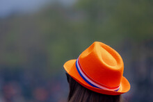 Colour Of The King's Day With Woman Wearing Orange Hat With Netherlands Flag Striped (red, White And Blue) Outdoor Party Celebration Birthday Of The King, National Holiday Koningsdag In Dutch, Holland